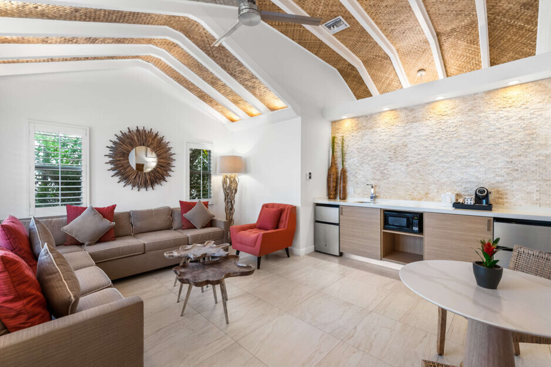 A wide view of a living room with a kitchenette, sofa, coffee table, and dining table.