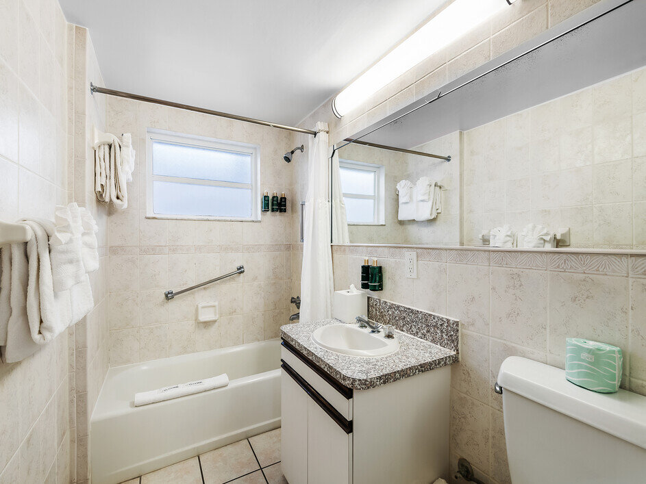 A clean and well-appointed bathroom with a tub, sink, toilet, and shower.